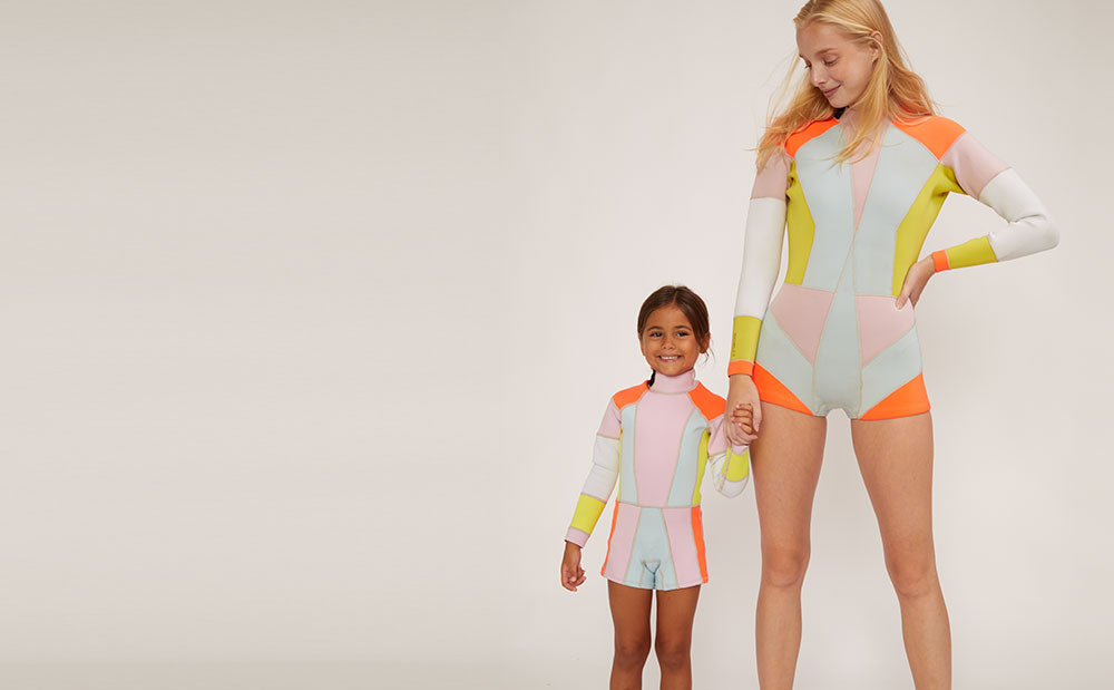Image featuring Mommy and me matching color block wetsuits.